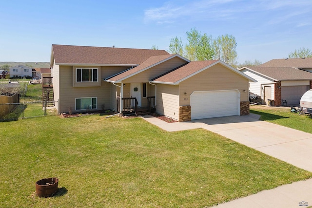 573 Plover Dr, Box Elder, SD 57719 - split level home featuring an attached garage, concrete driveway, and roof with shingles