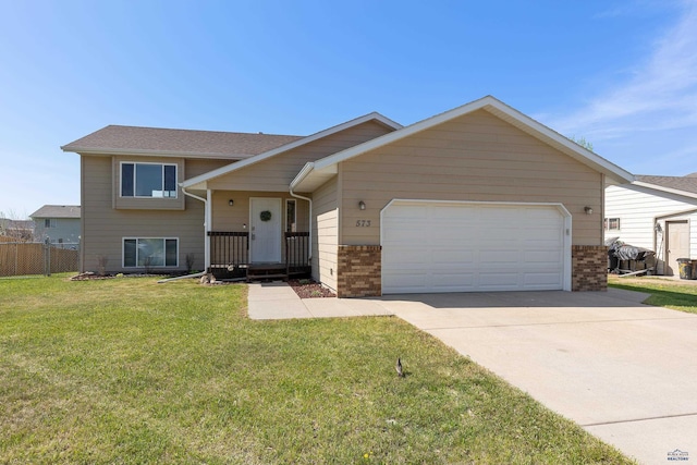 573 Plover Dr, Box Elder, SD 57719 - tri-level home featuring an attached garage, concrete driveway, and brick siding