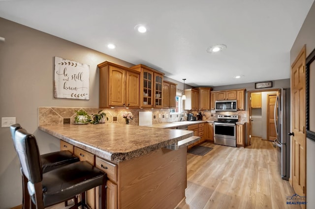 2930 Princeton Ct, Rapid City, SD 57702 - kitchen with stainless steel appliances, a peninsula, glass insert cabinets, a kitchen bar, and recessed lighting