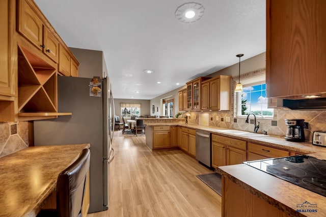 2930 Princeton Ct, Rapid City, SD 57702 - kitchen with a sink, appliances with stainless steel finishes, a peninsula, light wood-style floors, and backsplash