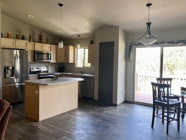 1064 Quinn Dr, Hill City, SD 57745 - kitchen featuring stainless steel appliances, light brown cabinetry, dark wood-type flooring, a kitchen island, and a textured ceiling