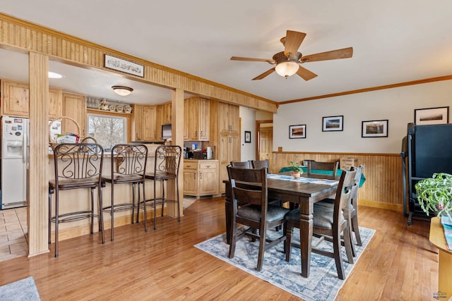 2030 12th Ave, Belle Fourche, SD 57717 - dining area featuring a ceiling fan, light wood finished floors, a wainscoted wall, and ornamental molding