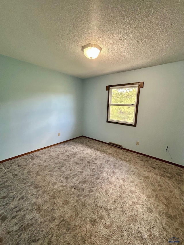1504 Morningside Dr, Rapid City, SD 57701 - spare room featuring carpet floors, a textured ceiling, and baseboards