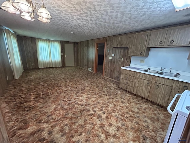 1504 Morningside Dr, Rapid City, SD 57701 - kitchen with a sink, stove, wooden walls, light countertops, and open floor plan