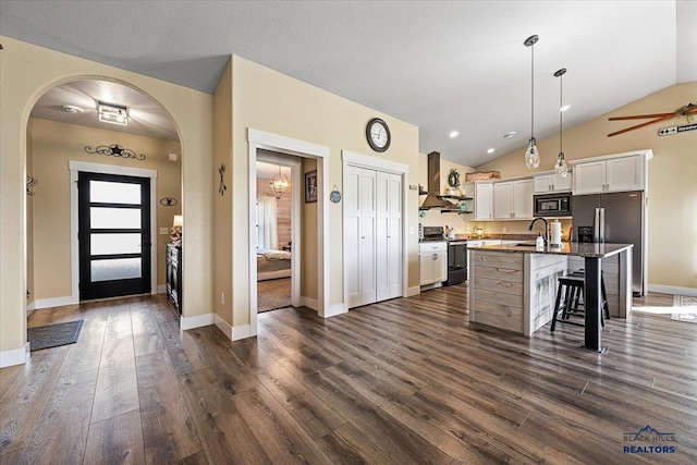 8009 Brooks Loop, Spearfish, SD 57783 - kitchen with range with electric stovetop, black microwave, a kitchen breakfast bar, wall chimney exhaust hood, and vaulted ceiling