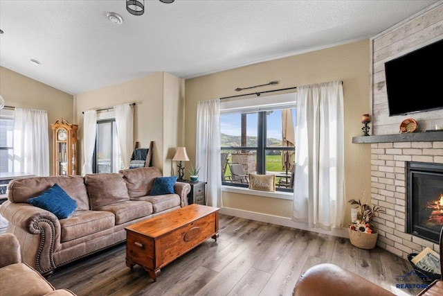 8009 Brooks Loop, Spearfish, SD 57783 - living room with a brick fireplace, wood finished floors, and lofted ceiling