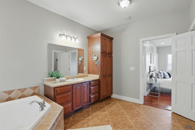 960 Nicole St, Rapid City, SD 57701 - bathroom featuring a garden tub, vanity, tile patterned floors, baseboards, and connected bathroom