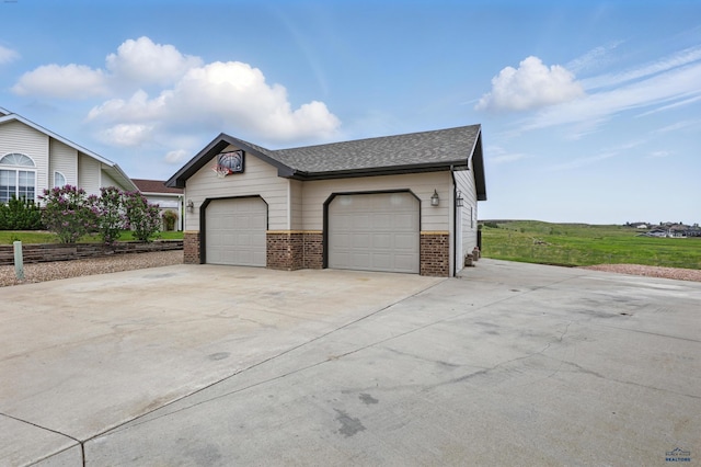 960 Nicole St, Rapid City, SD 57701 - view of side of home featuring brick siding, driveway, an outdoor structure, and a shingled roof
