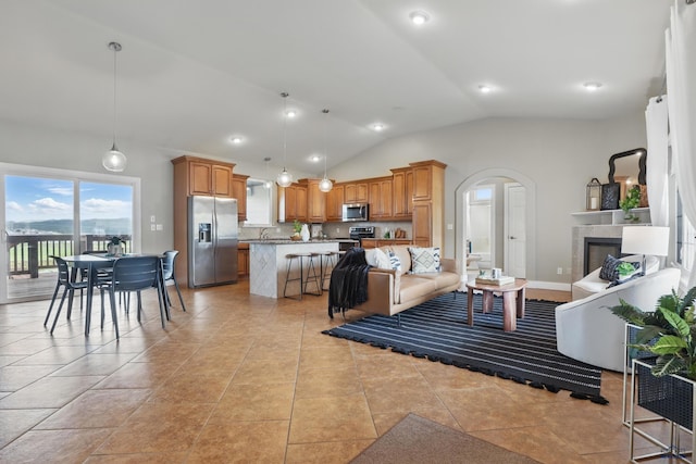 960 Nicole St, Rapid City, SD 57701 - living area featuring vaulted ceiling, arched walkways, a fireplace, and recessed lighting