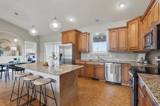960 Nicole St, Rapid City, SD 57701 - kitchen with appliances with stainless steel finishes, a sink, a breakfast bar area, and light stone countertops