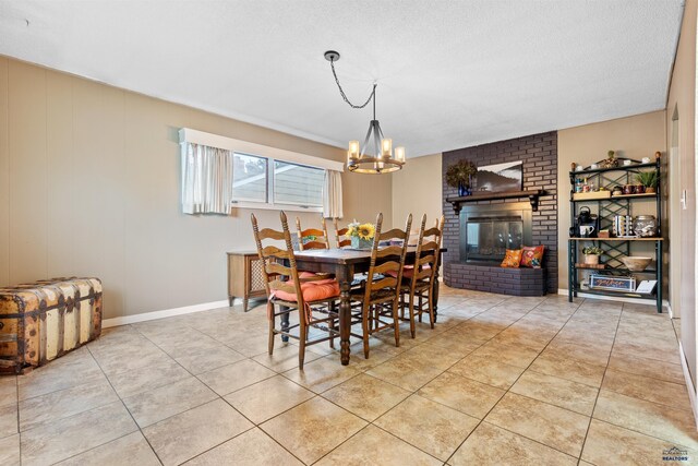 2739 W W St, Anne, Rapid City, SD 57701 - dining space featuring a chandelier, light tile patterned floors, a brick fireplace, baseboards, and a textured ceiling