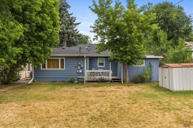 2739 W W St, Anne, Rapid City, SD 57701 - rear view of property with a storage unit, a lawn, an outbuilding, and a wooden deck