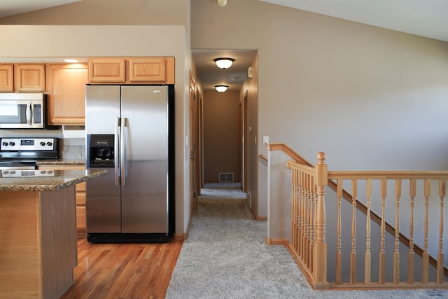 755 Field View Dr, Rapid City, SD 57701 - kitchen featuring appliances with stainless steel finishes, light wood-type flooring, stone countertops, vaulted ceiling, and light brown cabinetry