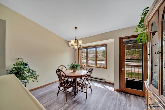 4801 Prairie Rose Pl, Rapid City, SD 57702 - dining room featuring baseboards, a baseboard heating unit, a chandelier, and light wood-style flooring