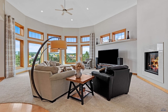 6717 Kennemer Dr, Rapid City, SD 57702 - carpeted living room with a premium fireplace, a high ceiling, ceiling fan, baseboards, and recessed lighting
