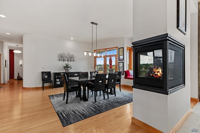 6717 Kennemer Dr, Rapid City, SD 57702 - dining space featuring light wood finished floors, recessed lighting, a multi sided fireplace, and baseboards