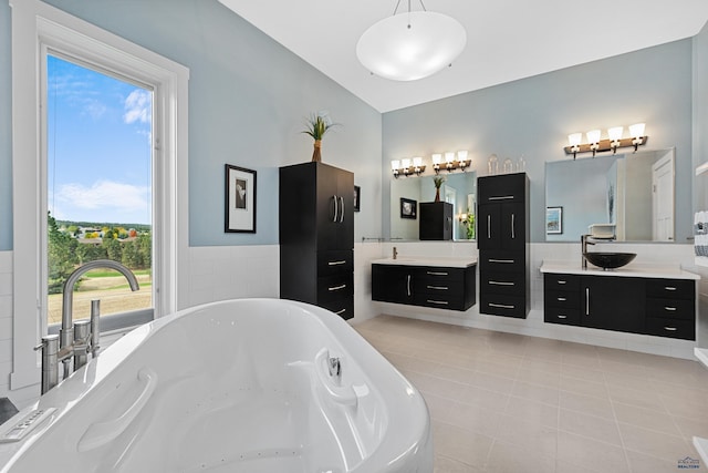 6717 Kennemer Dr, Rapid City, SD 57702 - full bath with a soaking tub, vaulted ceiling, tile patterned floors, and two vanities