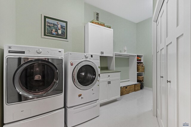 6717 Kennemer Dr, Rapid City, SD 57702 - clothes washing area with washing machine and clothes dryer, cabinet space, light tile patterned flooring, and baseboards