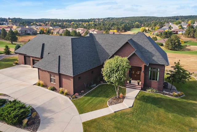 6717 Kennemer Dr, Rapid City, SD 57702 - view of front of house featuring brick siding, a shingled roof, concrete driveway, a front yard, and a residential view