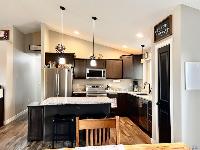3620 Remington Rd, Rapid City, SD 57703 - kitchen featuring appliances with stainless steel finishes, a sink, lofted ceiling, light wood-style flooring, and a center island