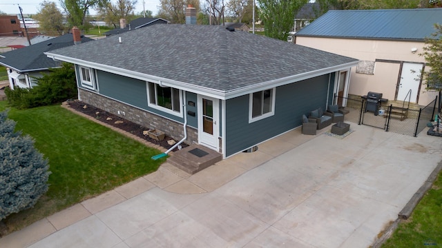 1421 12th Ave, Belle Fourche, SD 57717 - back of property with roof with shingles, a gate, a patio area, and an outdoor hangout area