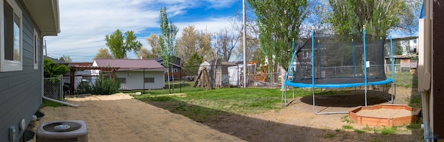 1421 12th Ave, Belle Fourche, SD 57717 - view of yard featuring a trampoline, a shed, an outdoor structure, and central AC