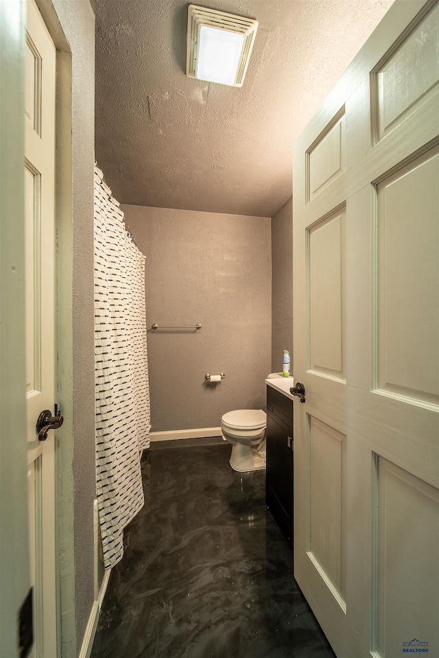 1421 12th Ave, Belle Fourche, SD 57717 - full bath featuring toilet, a textured ceiling, vanity, concrete flooring, and baseboards