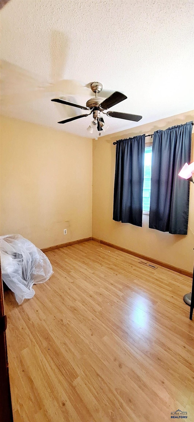 4737 Haven, Rapid City, SD 57703 - empty room with wood finished floors, ceiling fan, a textured ceiling, and baseboards