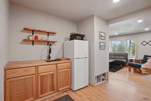 385 15th St, Sturgis, SD 57785 - kitchen featuring freestanding refrigerator, black microwave, light wood finished floors, a sink, and recessed lighting