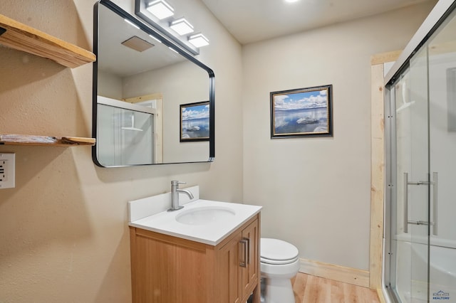 385 15th St, Sturgis, SD 57785 - full bathroom with wood finished floors, a stall shower, vanity, toilet, and baseboards