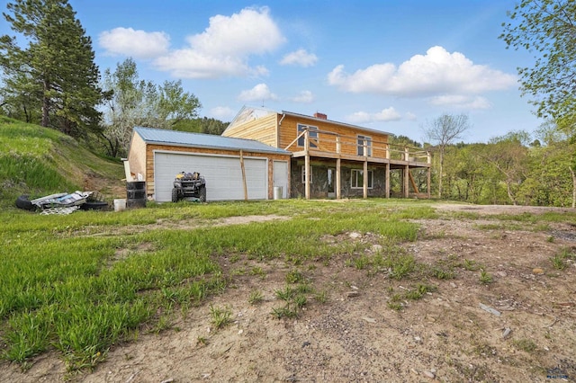 385 15th St, Sturgis, SD 57785 - back of house featuring a chimney, a deck, an attached garage, and dirt driveway