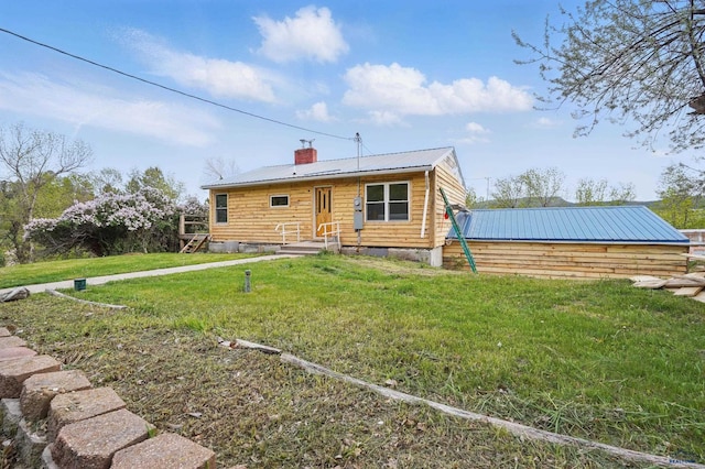 385 15th St, Sturgis, SD 57785 - view of front of home featuring metal roof, a chimney, and a front lawn