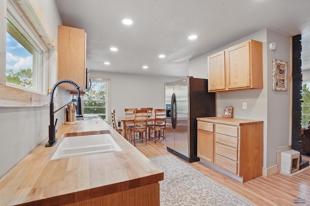 385 15th St, Sturgis, SD 57785 - kitchen with butcher block counters, stainless steel fridge with ice dispenser, recessed lighting, light brown cabinetry, and light wood finished floors