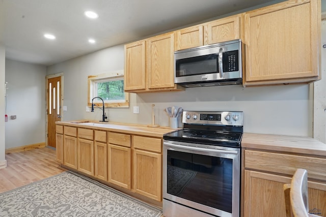 385 15th St, Sturgis, SD 57785 - kitchen with appliances with stainless steel finishes, a sink, light brown cabinets, butcher block countertops, and recessed lighting