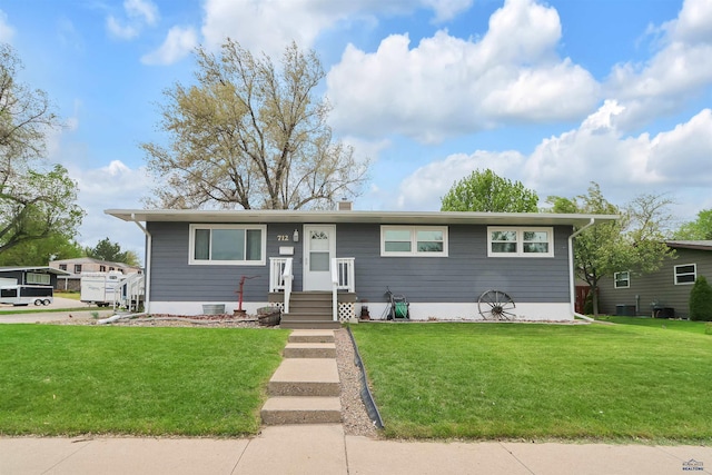 712 Stanley, Belle Fourche, SD 57717 - view of front of home featuring a front yard, cooling unit, and a chimney
