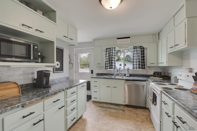 712 Stanley, Belle Fourche, SD 57717 - kitchen featuring appliances with stainless steel finishes, a sink, decorative backsplash, and white cabinets