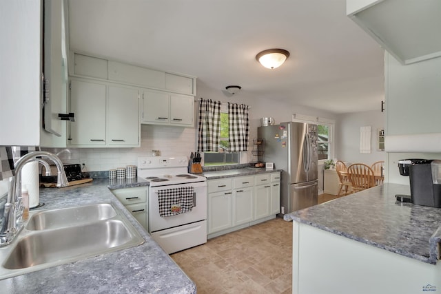 712 Stanley, Belle Fourche, SD 57717 - kitchen with white electric range oven, freestanding refrigerator, a sink, decorative backsplash, and white cabinets