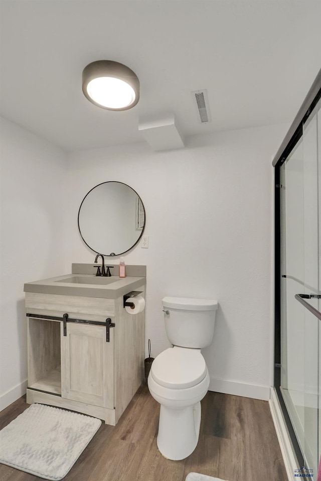 712 Stanley, Belle Fourche, SD 57717 - bathroom featuring wood finished floors, toilet, vanity, and baseboards