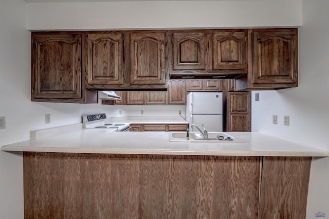 3968 Fairway Hills Dr, Rapid City, SD 57702 - kitchen featuring white appliances, a peninsula, a sink, range hood, and light countertops