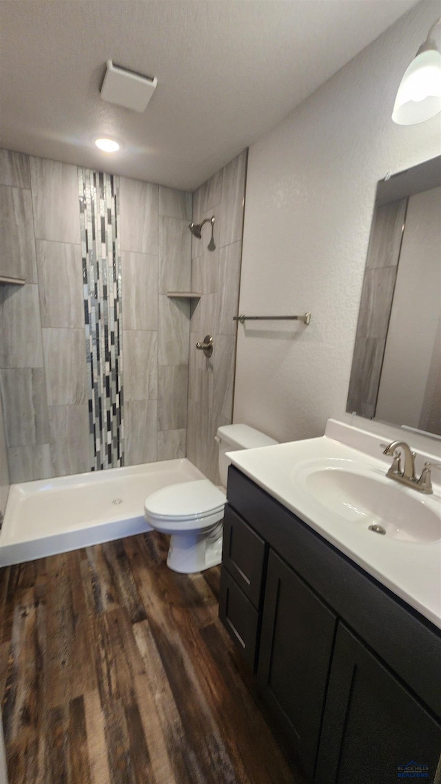 453 Yelner Dr Lot 14Blk 5, Box Elder, SD 57719 - bathroom with toilet, vanity, tiled shower, and wood finished floors