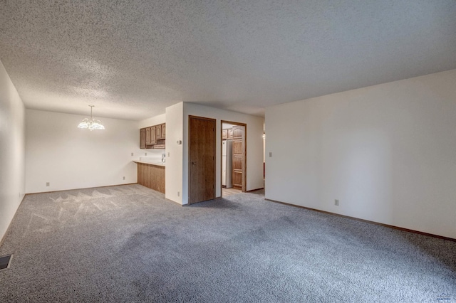 3965 Fairway Hills Dr, Rapid City, SD 57702 - unfurnished living room with light colored carpet, a chandelier, a textured ceiling, and baseboards