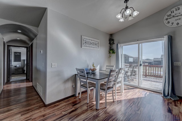 22970 Candlelight Dr, Rapid City, SD 57703 - dining space with vaulted ceiling, wood finished floors, a chandelier, arched walkways, and baseboards