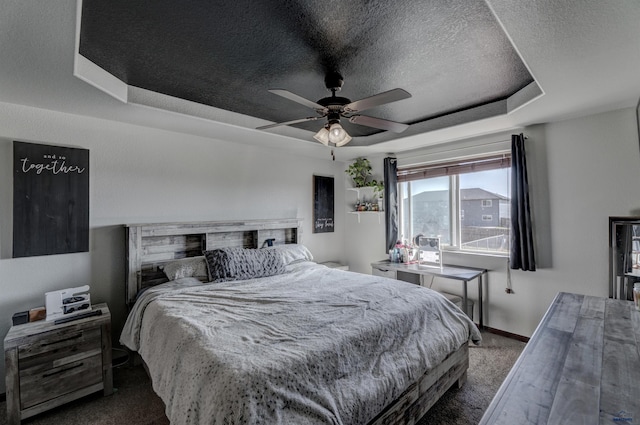22970 Candlelight Dr, Rapid City, SD 57703 - bedroom with carpet, a raised ceiling, a textured ceiling, baseboards, and ceiling fan
