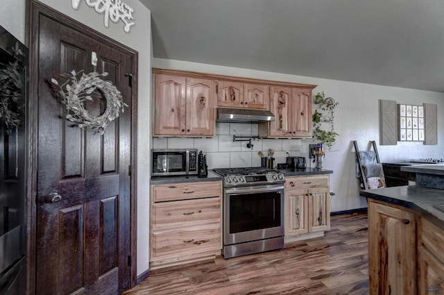 22970 Candlelight Dr, Rapid City, SD 57703 - kitchen featuring stainless steel appliances, dark countertops, under cabinet range hood, and backsplash