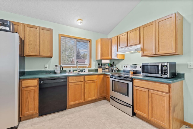 5436 Weathervane Ln, Rapid City, SD 57703 - kitchen featuring appliances with stainless steel finishes, under cabinet range hood, a sink, vaulted ceiling, and dark countertops