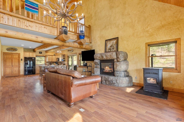 22600 Jenny Gulch Rd Unit 22600/22636Jenny, Gulch Rd, Rapid City, SD 57702 - living room with a chandelier, light wood-style flooring, a high ceiling, a lit fireplace, and a wood stove