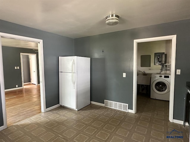 204 3rd Ave, Edgemont, SD 57735 - kitchen with washer / clothes dryer, freestanding refrigerator, baseboards, a sink, and dark floors