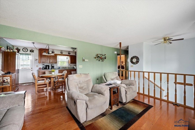 720 S 32nd, Spearfish, SD 57783 - living room with light wood finished floors, a ceiling fan, and a textured ceiling