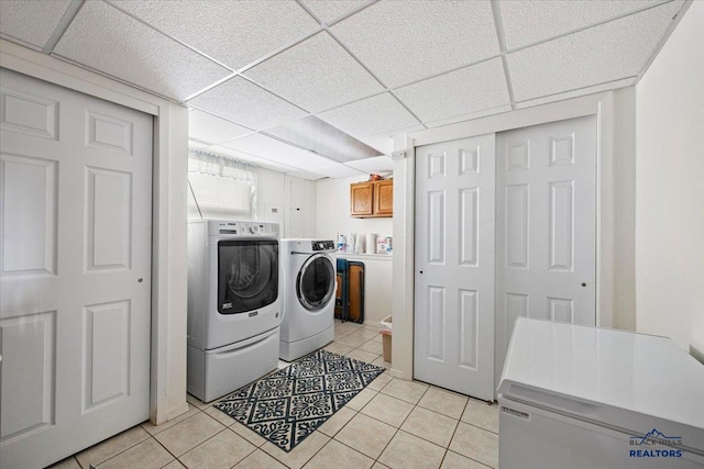 720 S 32nd, Spearfish, SD 57783 - washroom featuring washing machine and dryer, light tile patterned floors, and cabinet space
