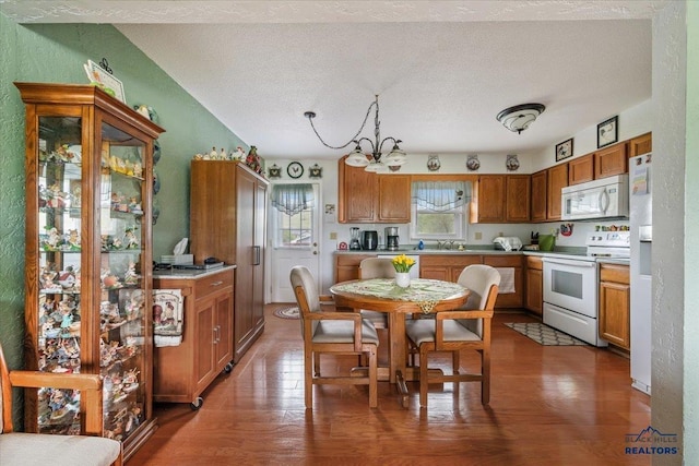720 S 32nd, Spearfish, SD 57783 - kitchen featuring white appliances, a chandelier, wood finished floors, brown cabinets, and a textured ceiling